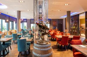 a restaurant with tables and chairs and a wine bottle at Leonardo Hotel Bad Kreuznach in Bad Kreuznach