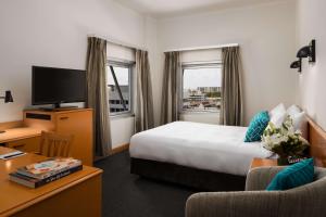 Habitación de hotel con cama y TV en Rydges Darwin Central en Darwin