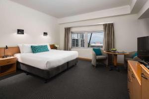 Habitación de hotel con cama y ventana en Rydges Darwin Central en Darwin
