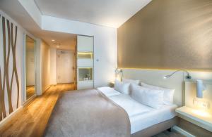 a bedroom with a bed with white pillows at Leonardo Hotel Berlin Mitte in Berlin