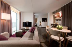 a living room with a couch and a table at Leonardo Hotel Berlin Mitte in Berlin