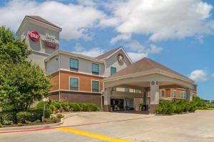 una vista frontal de un hotel con una señal de stop en Best Western Plus Denton Inn & Suites en Denton