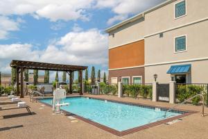 a swimming pool in front of a building at Best Western Plus Denton Inn & Suites in Denton
