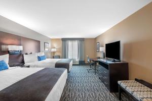 デントンにあるBest Western Plus Denton Inn & Suitesのベッド2台、薄型テレビが備わるホテルルームです。