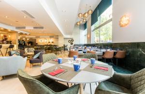 un comedor con mesas y sillas y un restaurante en Leonardo Hotel Barcelona Gran Via, en Barcelona