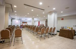 une chambre avec une rangée de chaises et une table dans l'établissement Leonardo Hotel Madrid City Center, à Madrid