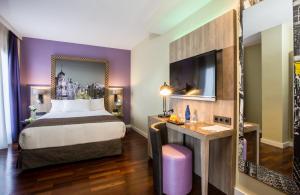 a hotel room with a bed and a desk at Leonardo Hotel Madrid City Center in Madrid