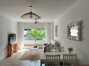 un salon avec une table et des chaises et une vue sur l'océan dans l'établissement Apartamento en Los Cristianos urb.Playa Graciosa, à Los Cristianos