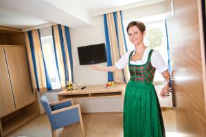 a woman in a dress standing in a kitchen at Bauernwirt in Graz