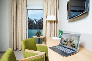 Ordenador portátil en un escritorio en una habitación con ventana en Bauernwirt en Graz