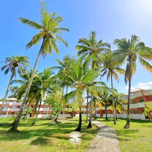 uma fila de palmeiras em frente a um edifício em Apartamento à beira-mar: ideal para famílias . em Ilhéus