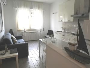 un soggiorno con divano e una cucina di Monica's Apartment a Marina di Carrara