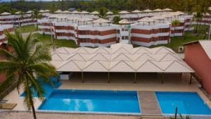uma vista aérea de um resort com uma piscina em Apartamento à beira-mar: ideal para famílias . em Ilhéus