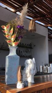 a vase with flowers on top of a counter at Casa Árabe in Bacalar