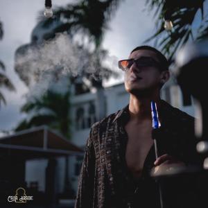 un hombre con gafas y un cigarrillo en Casa Árabe, en Bacalar