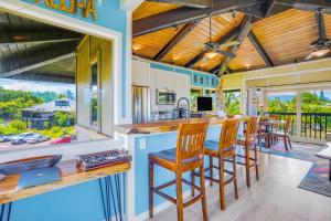 a kitchen with a bar with wooden stools at View House Tower! in Princeville