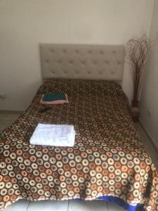 a bed with a comforter on it in a room at Remedios de escalada Suite! Wifi Aire cable in Villa María