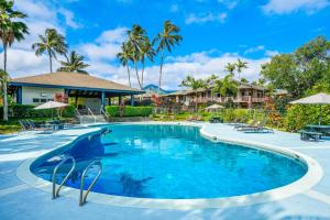 a swimming pool at a resort with palm trees at View House Tower! in Princeville