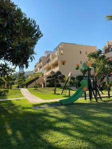 un parque infantil con tobogán en Nice ground floor apartment- 2 bedrooms - 450 meters from the beach, en Cabopino