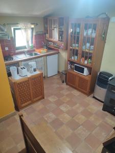 a kitchen with wooden cabinets and a tiled floor at Quinta do Borges in Guarda