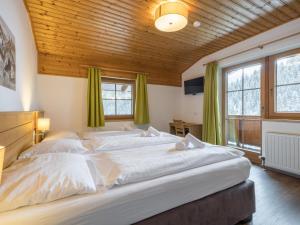 a bedroom with a large bed with green curtains at Alpensteinbock Saalbach C in Saalbach-Hinterglemm