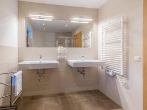 a bathroom with two sinks and a mirror at Alpensteinbock Saalbach C in Saalbach-Hinterglemm