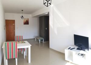 sala de estar con mesa blanca y TV en ADS DEPARTAMENTOS 1, en La Plata