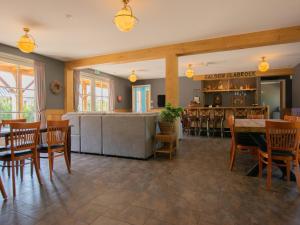 a restaurant with tables and chairs and a bar at Lodge Slabroek in Uden