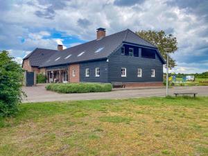 a large gray building with a bench in front of it at Lodge Slabroek in Uden