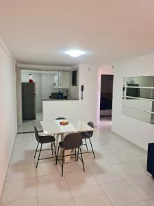 a kitchen and dining room with a white table and chairs at Solar Areia Preta 302 in Natal