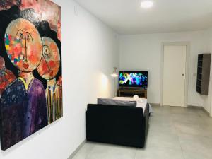 a room with a painting on the wall and a television at Buenavista in Picassent