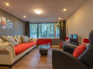 sala de estar con sofá y TV en Berghuisje, en Uden