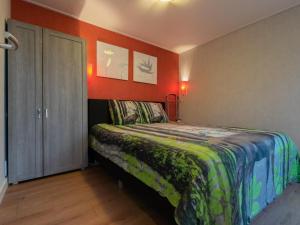 a bedroom with a bed and a red wall at Berghuisje in Uden