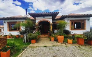 Casa Campestre Flores Amarillas في فيلا دي ليفا: منزل أمامه الكثير من النباتات