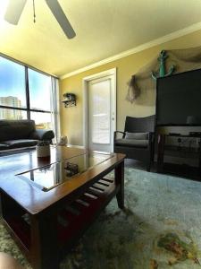 sala de estar con mesa de centro y TV en Biloxi Beach Condo en Biloxi