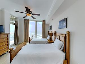 1 dormitorio con 2 camas y ventilador de techo en Portofino Island Resort 3-1209, en Pensacola Beach