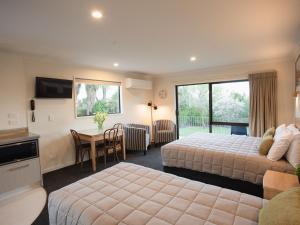 ein Hotelzimmer mit 2 Betten und einem Tisch in der Unterkunft Wanaka Top 10 Holiday Park in Wanaka