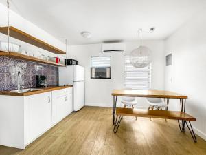 a kitchen with white cabinets and a wooden table at Ocean Sound's Hotel in Hollywood