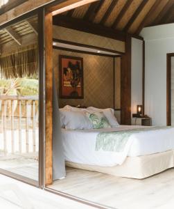um quarto com uma grande cama branca em um quarto em Maitai Bora Bora em Bora Bora