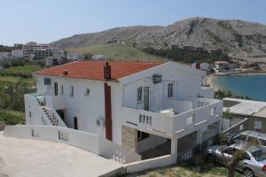 biały dom z czerwonym dachem w obiekcie Apartments by the sea Metajna, Pag - 6336 w mieście Metajna