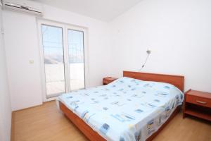 een slaapkamer met een bed en een groot raam bij Apartments by the sea Metajna, Pag - 6336 in Metajna