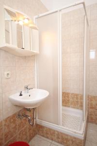 een badkamer met een wastafel en een douche bij Apartments by the sea Metajna, Pag - 6336 in Metajna