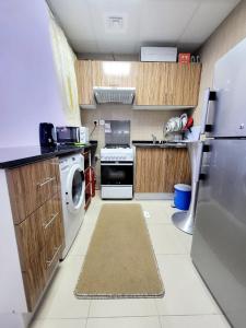 a kitchen with a refrigerator and a washer and dryer at Cheap Holiday Home in Ajman 