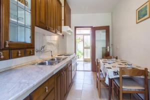 a kitchen with a sink and a table with chairs at Apartment Umag 7063b in Umag