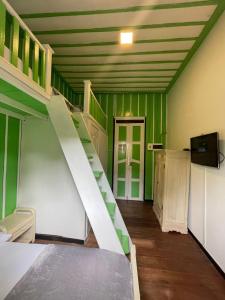 a room with a staircase and green walls at La Posada de La Abuela Salento in Salento