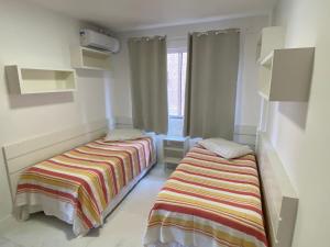 1 dormitorio con 2 camas y ventana en Apartamento com piscina Condomínio Balneário Camboriú, en Balneário Camboriú