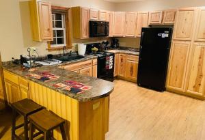 a kitchen with a black refrigerator and wooden cabinets at The Barn in Asheville