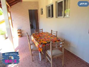 a table with two chairs and a table with a quilt on it at Recanto da Garça in Guarda do Embaú