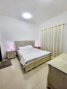 1 dormitorio con 1 cama grande y 2 mesitas de noche en Cheap Holiday Home, en Ajman