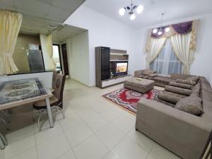 a large living room with a couch and a tv at Cheap Holiday Home in Ajman 